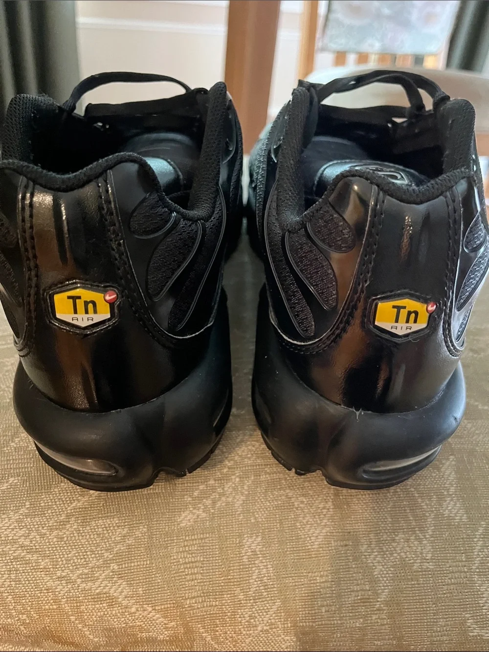 Nike Air Max Plus (Men’s) Triple Black Sneakers with Subtle Red Interior Accents